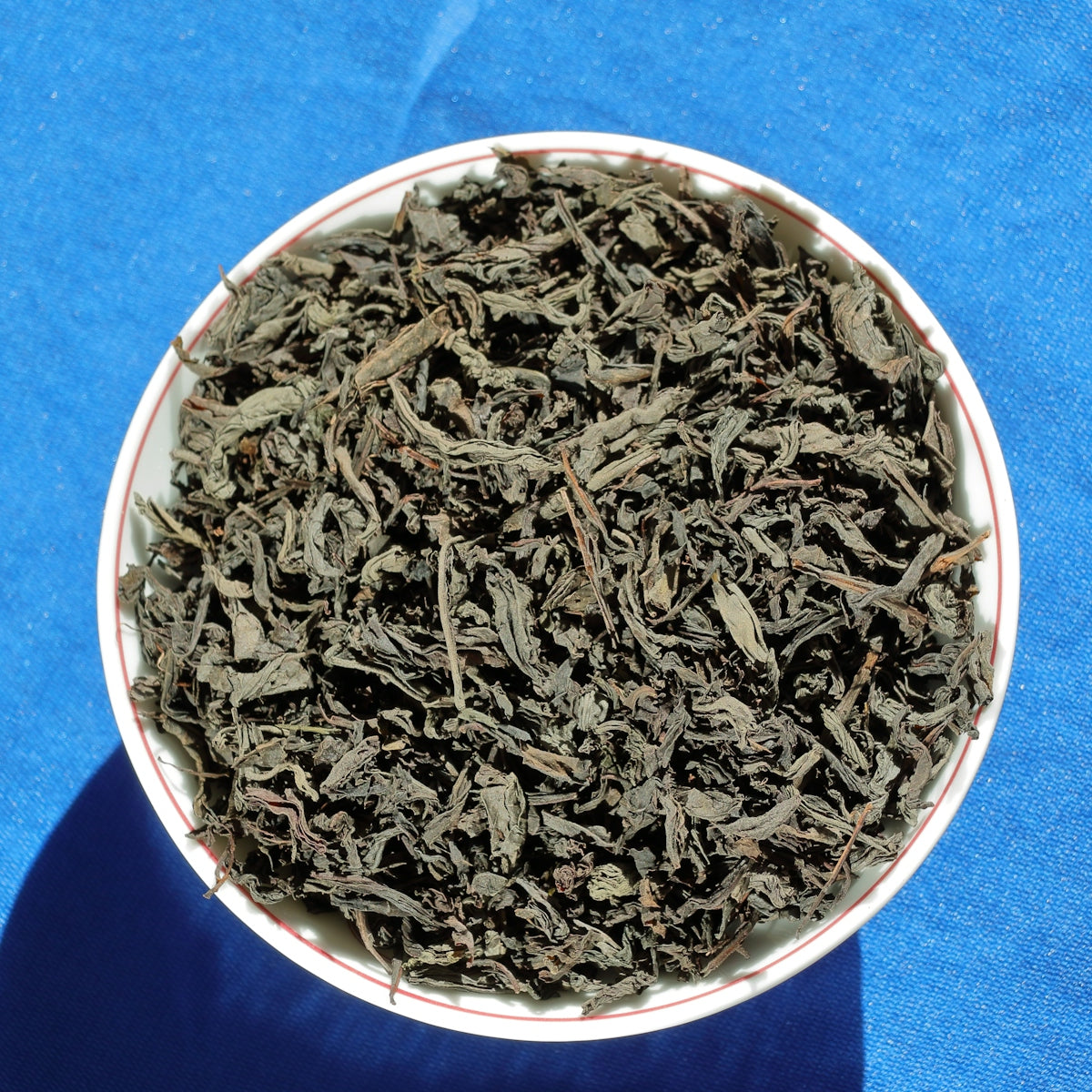 a white bowl filled with green tea on a blue surface