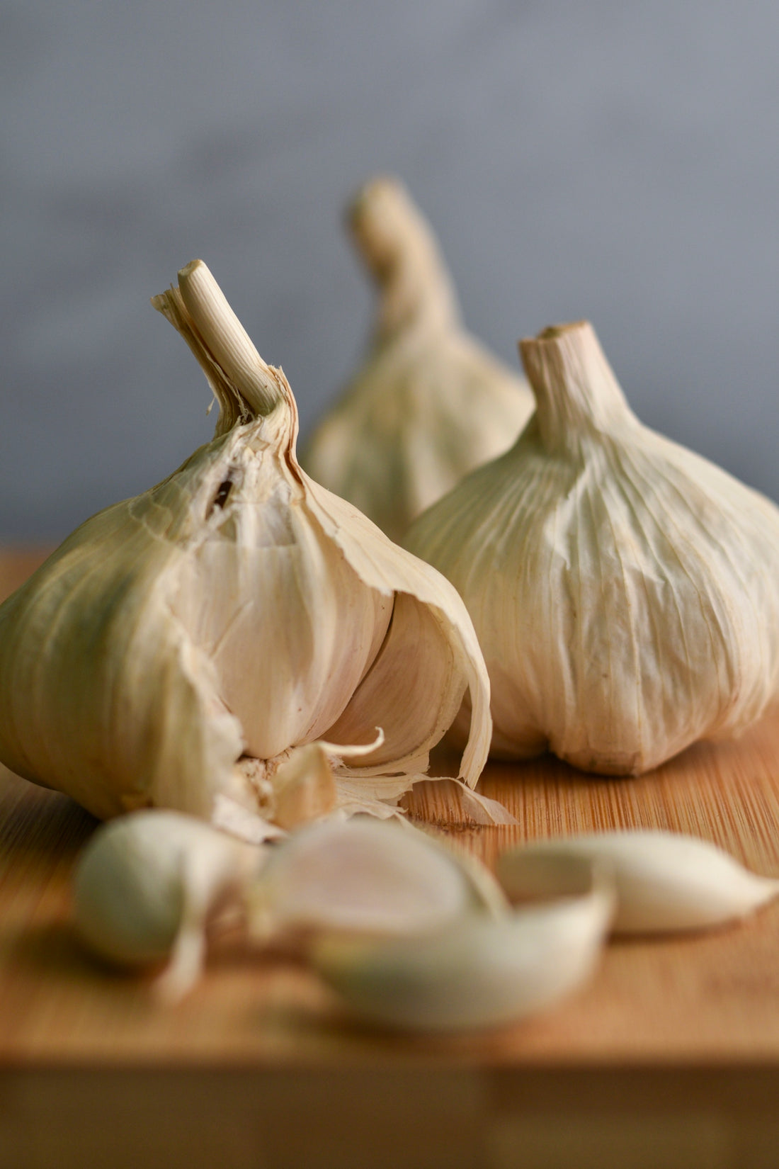 a couple of garlics sitting on top of a wooden cutting board