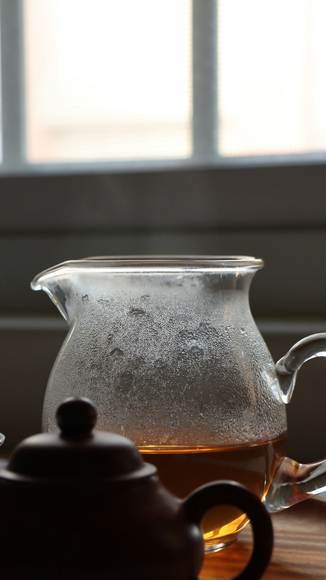 A pitcher of tea next to a cup of tea